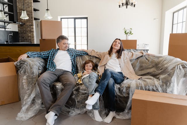 Familia feliz descansando en el sofá en una mudanza